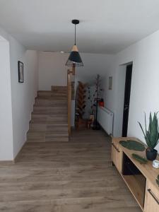 a living room with a staircase and a pendant light at Pensiunea Sufletul Pădurii in Valea Lupului +28 photos