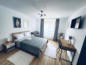 a bedroom with a bed and a table and a desk at Pensiunea Sufletul Pădurii in Valea Lupului