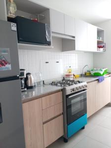 a kitchen with white cabinets and a stove top oven at Alto Alborada Cercado in Lima