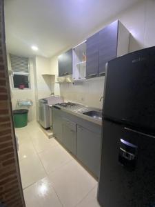 a kitchen with a black refrigerator in a room at apartamento cerca al mar in Estación El Salto +7 photos