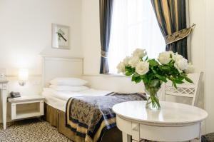 una habitación de hotel con una mesa con un jarrón de flores en Park Rekreacyjno-Biznesowy Las Woda, en Wilga