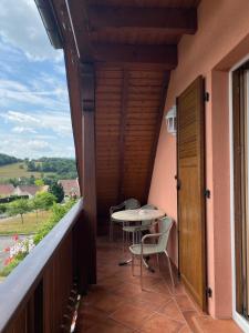 a balcony with a table and chairs on it at Le Val Charmant in Thanvillé
