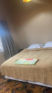 a bedroom with a bed with a blanket on it at Alojamiento Napoleon in Puerto Iguazú