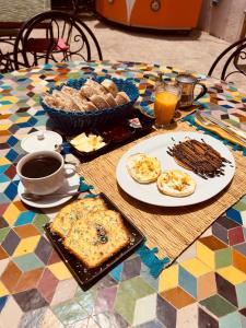 a table with plates of food and cups of coffee at Yousurf Surf House in Essaouira