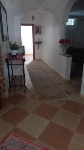 a room with a floor with a table and a piano at khadija oulidia in Oualidia