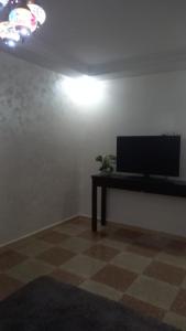 a living room with a television and a table at khadija oulidia in Oualidia