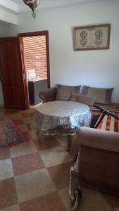 a living room with a table and a couch at khadija oulidia in Oualidia