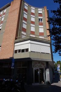 a tall building with a sign in front of it at Hotel San Marco in Pesaro