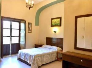 a bedroom with a bed and a dresser and a mirror at Hotel La Casona del Vizconde in Guanajuato