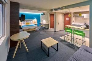 a hotel room with a bed and a living room at City Express by Marriott Toluca in Toluca