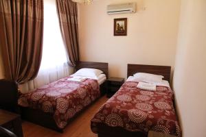 een hotelkamer met twee bedden en een raam bij Satti in Zharkent