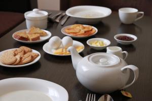 een tafel met borden eten en een theepot bij Satti in Zharkent