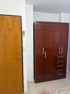 a wooden cabinet and a door in a room at Departamento torre Sarmiento in Resistencia