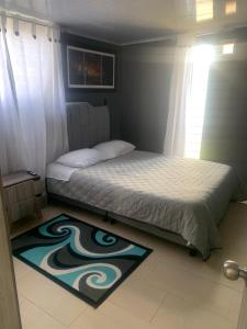 a bedroom with a bed and a rug on the floor at Cabaña La Conquista in Chivatá