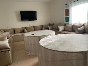 a living room with a couch and two tables at Havre de paix dans les montagnes in Amizmiz