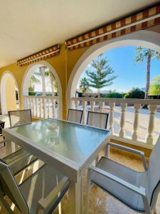 een eetkamer met een tafel en stoelen en een balkon bij villa OLM in Ciudad Quesada