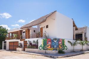 une maison avec une fresque murale sur son côté dans l'établissement Lagoon Boutique Hotel - Luxury Chaman experience, à Tulum