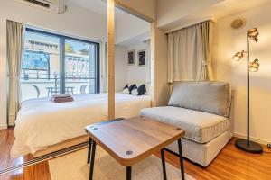 a bedroom with a bed and a chair and a window at Shinjuku 10 min walk, Higashi Shinjuku 4 min, Kabukicho, Shin-Okubo apartment in Tokyo