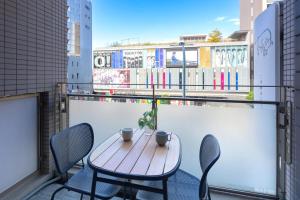 a wooden table and chairs on a balcony at Shinjuku 10 min walk, Higashi Shinjuku 4 min, Kabukicho, Shin-Okubo apartment in Tokyo