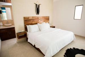 - une chambre avec un grand lit blanc et un lavabo dans l'établissement Lagoon Boutique Hotel - Luxury Chaman experience, à Tulum