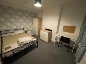 a bedroom with a bed and a desk and a chair at 4 Double Bedroom House with Private Garden and Own Entrance in Henwick