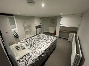 a bedroom with a large bed and white cabinets at 4 Double Bedroom House with Private Garden and Own Entrance in Henwick