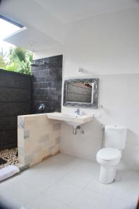 烏布的住宿－素吉旅館，浴室配有白色卫生间和盥洗盆。