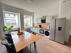 a large kitchen with a table and a refrigerator at XXL City Apartment - 5 bedrooms - free parking - MalliBase Apartments in Hannover