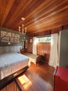 a bedroom with a large bed and a window at Chale lá bella villa in Palhoça