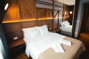 a bedroom with a large bed with white pillows at Zlatibor Lux Spa Apartments in Zlatibor