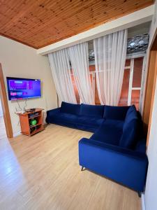 a living room with a blue couch and a tv at La Piscina in Shkodër