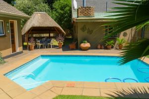 a swimming pool in a yard with a gazebo at Horison Meyer Guest Suites in Meyerton