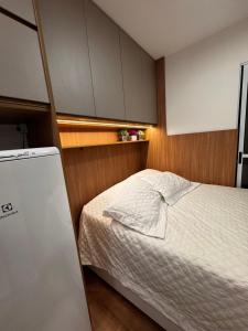 ein kleines Schlafzimmer mit einem Bett und einem Kühlschrank in der Unterkunft Studio Apartamento no Morumbi próximo ao Estádio Morumbi estação de ônibus metrô e shopping in São Paulo