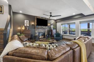 ein Wohnzimmer mit einem braunen Ledersofa in der Unterkunft Lakeview Lodge for 36 with Indoor & Outdoor Pool in Hollister