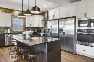 eine Küche mit weißen Schränken und eine große Insel mit Barhockern in der Unterkunft Lakeview Lodge for 36 with Indoor & Outdoor Pool in Hollister