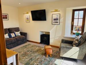 a living room with a couch and a fireplace at Peedie Orkney Cottage with Hot Tub in Orkney