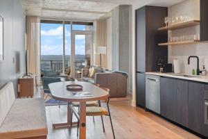 a kitchen with a table and a living room with a view at Del Rio at the Rainey District in Austin
