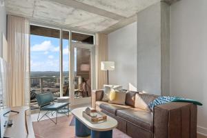 a living room with a couch and a table at Del Rio at the Rainey District in Austin +27 photos