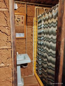 a bathroom with a sink and a shower curtain at Caminho das Montanhas eco in Itanhandu
