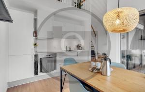 a kitchen with a wooden table and blue chairs at Havnehusene, Lejl 36 in Slagelse