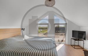 a white bedroom with a bed and a window at Havnehusene, Lejl 36 in Slagelse
