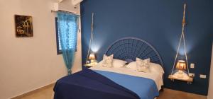een blauwe slaapkamer met een bed met twee katten erop bij Casa Giò in Las Terrenas