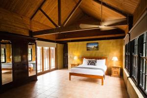 a bedroom with a bed in a room with windows at Peppers Creek Accommodation in Pokolbin