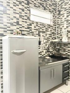 a kitchen with a refrigerator and a sink at Mar à porta in São Vicente