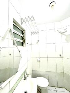 a white bathroom with a sink and a toilet at Mar à porta in São Vicente