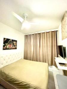a bedroom with a bed and a ceiling fan at Mar à porta in São Vicente