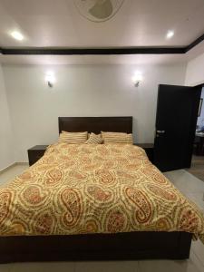 Un dormitorio con una cama grande con una colcha marrón. en Green Oasis, en Nathia Gali