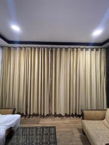 Un dormitorio con cortinas y un sofá y una cama. en Green Oasis, en Nathia Gali 3 fotos más
