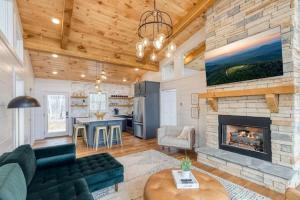 ein Wohnzimmer mit Kamin und eine Küche in der Unterkunft Modern Luxury - EV Charger Hot Tub & Epic Views in Blue Ridge