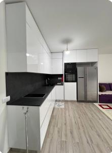 a kitchen with white cabinets and stainless steel appliances at Appartamenti ne qender te qytetit in Peje